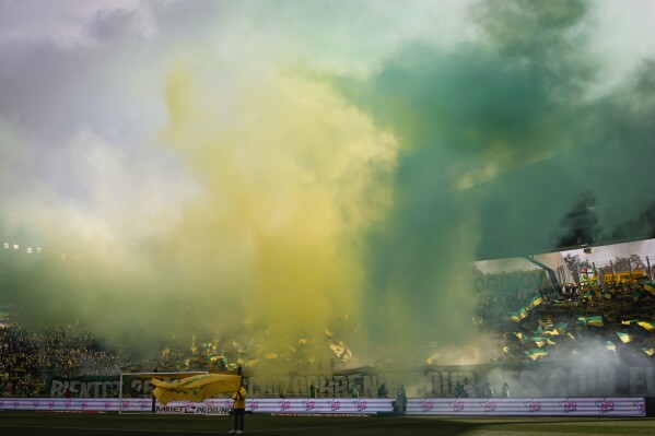 FILE - Smoke hangs over the field before the French League One soccer match between Nantes and Reims at the Stade de la Beaujoire stadium in Nantes, France, on Nov. 5, 2023. Nantes says one of its supporters has died following an assault before the club鈥檚 1-0 win over Nice in the French league, amid reports the fan was stabbed. Nantes said in a statement in the early hours of Sunday, Dec. 3, 2023 that the fan was 鈥渇atally injured鈥� close to the club's stadium. (AP Photo/Jeremias Gonzalez, File)