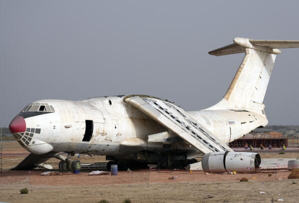 An abandoned plane, Ilyushin Il-76, once tied to arms smuggler Viktor Bout, is being dismantled at the old airfield of Umm al-Quwain, United Arab Emirates, Friday, May 27, 2022. The hulking, Soviet-era cargo plane has sat for decades under the blazing sun in this least-populated corner of the United Arab Emirates, its four jet engines silent after years in the employ of a Russian gunrunner infamously known as the "Merchant of Death." (AP Photo/Kamran Jebreili)