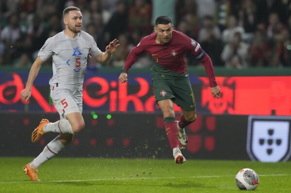 Portugal's Cristiano Ronaldo, right, is challenged by Iceland's Sverrir Ingi Ingason during the Euro 2024 group J qualifying soccer match between Portugal and Iceland, at the Alvalade Stadium in Lisbon, Sunday, Nov. 19, 2023. (AP Photo/Armando Franca)