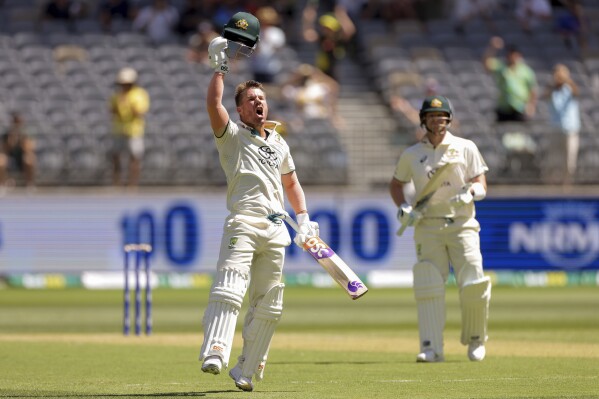 David Warner of Australia celebrates on reaching a century during play on the first day of the first cricket test between Australia and Pakistan in Perth, Australia, Thursday, Dec. 14, 2023. (Richard Wainwright/AAP Image via AP)