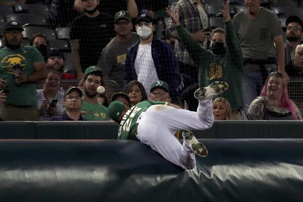 Oakland Athletics' Matt Chapman dives for a foul ball hit by Seattle Mariners' Jake Bauers during the fourth inning of a baseball game in Oakland, Calif., Tuesday, Sept. 21, 2021. (AP Photo/Jed Jacobsohn)
