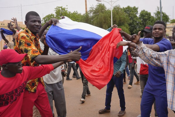 Supporters of mutinous soldiers hold a Russian flag as they demonstrate in Niamey, Niger, Thursday, July 27 2023. Governing bodies in Africa condemned what they characterized as a coup attempt Wednesday against Niger's President Mohamed Bazoum, after members of the presidential guard declared they had seized power in a coup over the West African country's deteriorating security situation. (AP Photo/Sam Mednick)