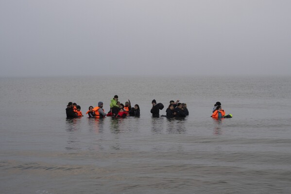 A group of Kurdish migrants from Iran and Iraq who failed in their attempt to reach the United Kingdom by boat after being discovered by the police refuse to return to shore on the beach of Ambleteuse, northern France, on Sunday, May 19, 2024. (AP Photo/Bernat Armangue)