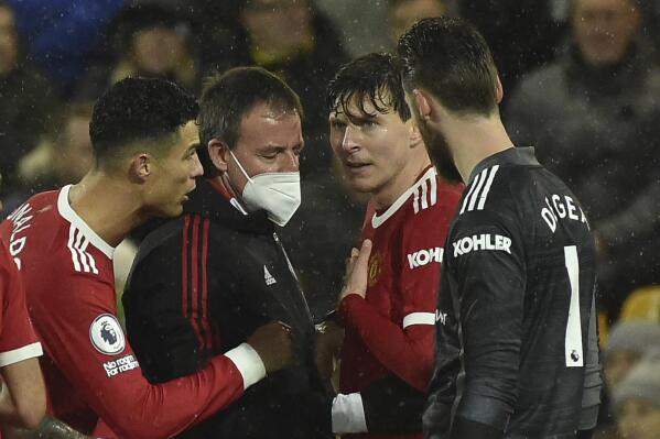 Manchester United's Cristiano Ronaldo, left and goalkeeper David de Gea, right, talk to Victor Lindelof, 3rd from left as he holds his chest before having to leave the field during the English Premier League soccer match between Norwich City and Manchester United at Carrow road in Norwich, England, Saturday, Dec.11, 2021. (AP Photo/Rui Vieira)