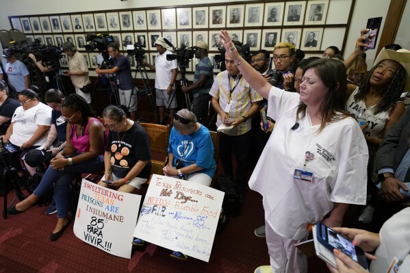 Advocates for cooling Texas prisons pray during a news conference at the Texas Capitol, Tuesday, July 18, 2023, in Austin, Texas. The group is calling for an emergency special session to address the deadly heat effecting inmates. (AP Photo/Eric Gay)