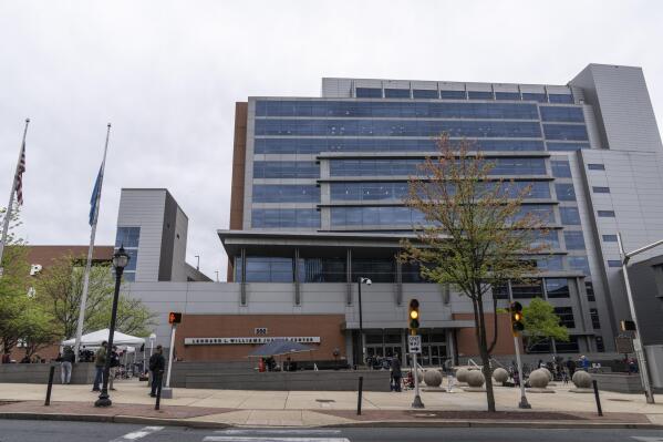 Members of the media gather outside the justice center in Wilmington, Del., Monday, April 17, 2023. The Delaware judge overseeing Dominion Voting Systems' defamation lawsuit against Fox News announced a delay in the start of the trial until Tuesday, giving no explanation in announcing the recess. (AP Photo/Matt Rourke)
