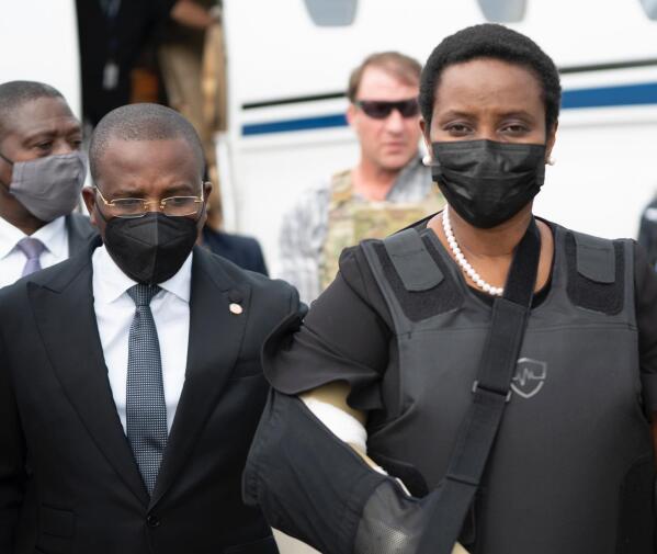 In this handout photo released by Haiti's Secretary of State for Communication, Haiti's first lady Martine Moise, wearing a bullet proof vest and her right arm in a sling, arrives at the Toussaint Louverture International Airport, in Port-au-Prince, Haiti, Saturday, July 17, 2021.  Martine Moise, the wife of assassinated President Jovenel Moise, who was injured in the July 7 attack at their private home, returned to the Caribbean nation on Saturday following her release from a Miami hospital. (Haiti's Secretary of State for Communication Photo/via AP)