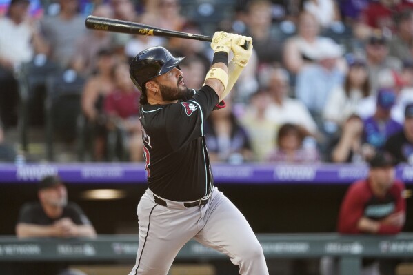 Arizona Diamondbacks' Eugenio Suárez follows the flight of his solo home run off Colorado Rockies starting pitcher Carson Palmquist in the third inning of a baseball game Saturday, June 21, 2025, in Denver. (AP Photo/David Zalubowski)