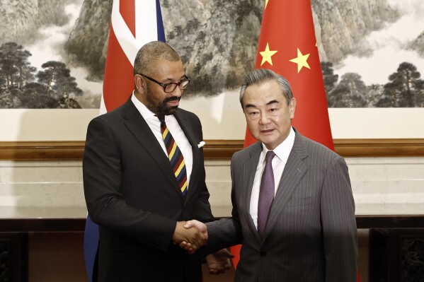 British Foreign Secretary James Cleverly, left, and Chinese Foreign Minister Wang Yi shake hands before a meeting at the Diaoyutai State Guesthouse in Beijing, Wednesday, Aug. 30, 2023. (Florence Lo/Pool Photo via AP)