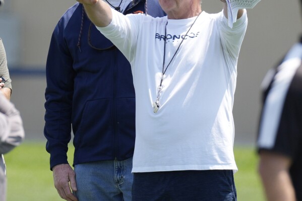 FILE - Denver Broncos head coach Sean Payton, front, chats with retired Broncos linebacker Karl Mecklenburg during NFL football practice, Wednesday, June 14, 2023, in Centennial, Colo. Sean Payton is back on the sideline and this time it's in Denver. The former Saints head coach was hired after spending a year in the broadcast booth. (AP Photo/David Zalubowski, File)