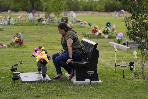 Veronica Mata visits the gravesite of her daugher, Tess, in Uvalde, Texas, Wednesday, May 3, 2023. For Mata, teaching kindergarten in Uvalde after her daughter was among the 19 students who were fatally shot at Robb Elementary School became a year of grieving for her own child while trying to keep 20 others safe. (AP Photo/Eric Gay)