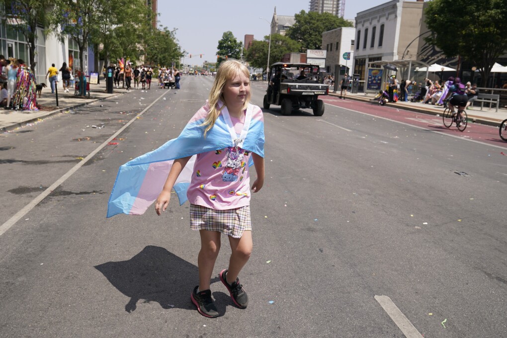 Flower Nichols walks down the street following the Pride Parade, Saturday, June 10, 2023, in Indianapolis. Families around the U.S. are scrambling to navigate new laws that prohibit their transgender children from accessing gender-affirming care. (AP Photo/Darron Cummings)