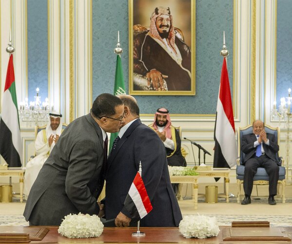 FILE - In this Nov. 5, 2019 file photo, released by the Saudi Royal Palace, Yemeni Southern Transitional Council member and former Aden Governor Nasser al-Khabji, left, and Yemen's deputy Prime Minister Salem al-Khanbashi greet each other before signing a power-sharing deal witnessed by Yemen's president, Abed Rabbo Mansour Hadi, background right, Saudi Arabia's Crown Prince Mohammed bin Salman, center, and Abu Dhabi's Crown Prince, Mohammed bin Zayed Al Nahyan, in Riyadh, Saudi Arabia. A bid by the separatists to assert control over Yemen’s south has reopened a dangerous new front in the country’s civil war and pushed Yemen closer to fragmentation -- at a time when the coronavirus pandemic poses a growing threat. (Bandar Aljaloud/Saudi Royal Palace via AP, File)