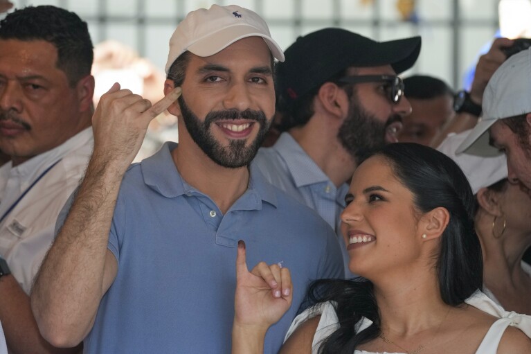 El Salvador President Nayib Bukele, who is seeking re-election, and his wife Gabriela Rodriguez show their inked fingers after voting in the general election in San Salvador, El Salvador, Sunday, Feb. 4, 2024. (AP Photo/Moises Castillo)