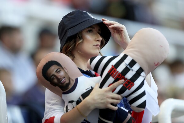 An England fan holds dolls of England's Jude Bellingham, left, and Kieran Trippier on the stands before an international friendly soccer match between England and Bosnia and Herzegovina at St. James Park in Newcastle, England, Monday, June 3, 2024. (AP Photo/Scott Heppell)