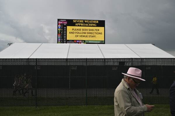 A sign warns of approaching sever weather at Churchill Downs before the 151st running of the Kentucky Oaks horse race Friday, May 2, 2025, in Louisville, Ky. (AP Photo/Jon Cherry)