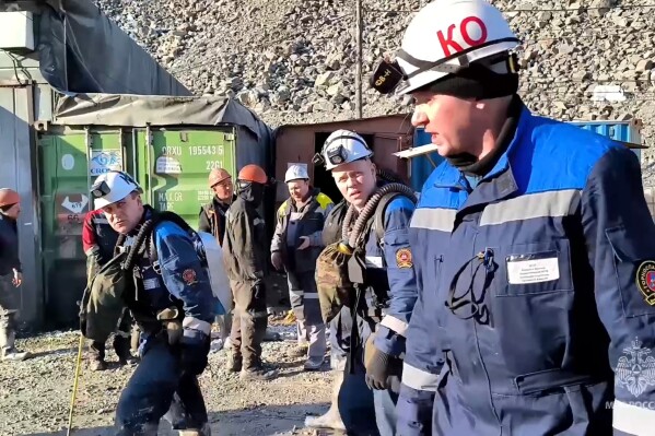 In this photo taken from video released by Russia Emergency Situations Ministry press service on Thursday, March 21, 2024, Russia Emergency Situations employees walk to the collapsed gold mine in Zeysk district, Amur region, eastern Russia. The Emergencies Ministry reported that 13 miners have been trapped, but the regional prosecutor's office said that up to 15 could remain underground. A rescue operation is underway. (Russia Emergency Situations Ministry press service via AP)