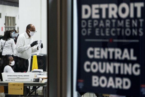 Election inspectors count ballots into the early morning hours of Wednesday, Nov. 4, 2020, at the central counting board in Detroit. (AP Photo/David Goldman)