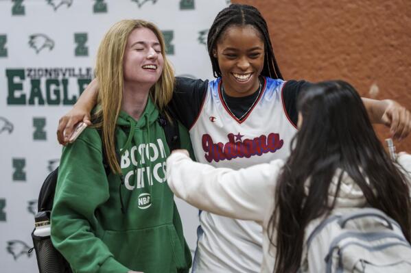 After being named IndyStar Miss Basketball, Zionsville High School's Laila Hull, center, gets a hug Monday, March 13, 2023, from teammates Allie Caldwell, left, and Faith Leedy Jr., right, in Zionsville, Ind. (Mykal McEldowney/The Indianapolis Star via AP)
