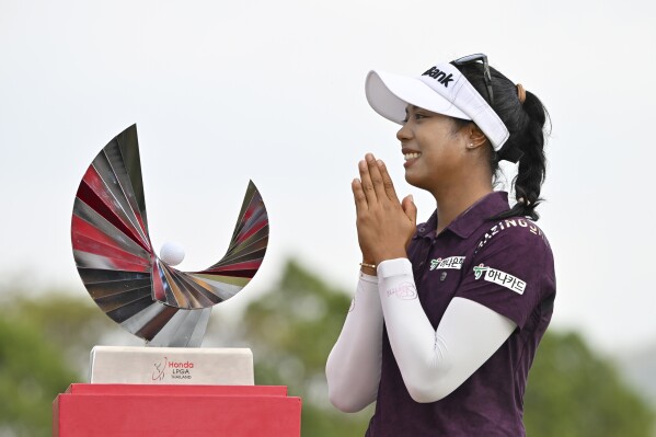 Patty Tavatanakit of Thailand reacts before a photo with her trophy during the award ceremony after winning the LPGA Honda Thailand golf tournament in Pattaya, southern Thailand, Sunday, Feb. 25, 2024. (AP Photo/Kittinun Rodsupan)