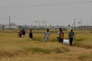Migrantes caminando cerca del centro de recepción de emergencia de Pournara, en Kokkinotrimithia, a las afueras de la capital, Nicosia, en Chipre, el lunes 18 de abril de 2022. (AP Foto/Petros Karadjias)