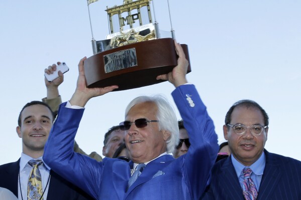 FILE - Triple Crown winner American Pharoah's trainer Bob Baffert, center, owner Ahmed Zayat, right, and his son Justin Zayat, left, celebrate with the winner's trophy after American Pharoah won the Haskell Invitational horse race at Monmouth Park in Oceanport, N.J., Sunday, Aug. 2, 2015. Baffert will look to add another Haskell Stakes and big payday to his collection when the lightly raced Arabian Knight takes on Kentucky Derby winner Mage and six others in the $1 million showcase event of the summer meet at Monmouth Park. (AP Photo/Mel Evans)