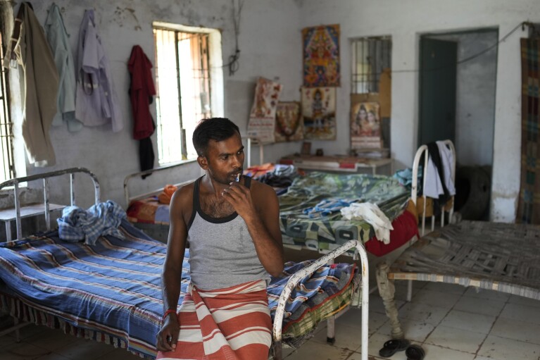 Jitendra Kumar, a paramedic who travels in an ambulance, brushes his teeth in a room he shares with several others at the district government hospital quarters, in Banpur in the Indian state of Uttar Pradesh, Sunday, June 18, 2023. Ambulance drivers and other healthcare workers in rural India are the first line of care for those affected by extreme heat. (AP Photo/Rajesh Kumar Singh)