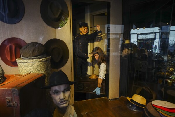 An employee arranges a display at the “Donde Golpea el Monito” hat shop and museum, which has preserved a hat-making tradition for more than a century, in Santiago, Chile, Thursday, April 3, 2025. (AP Photo/Esteban Felix)