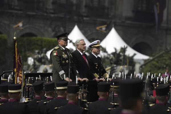 FILE - Mexico's President Andrés Manuel López Obrador, center, reviews military troops before the start of the annual Independence Day parade in the capital's main square, the Zocalo, in Mexico City, Sept. 16, 2023. Mexico’s president dissolved the old federal police, accusing them of corruption, and cut almost all federal funding for training and equipping local police. (AP Photo/Fernando Llano, File)