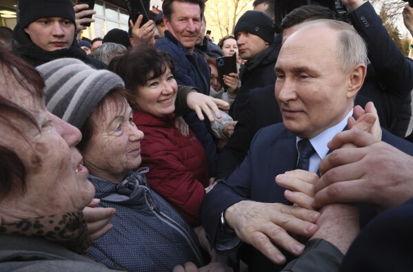 FILE - Russian President Vladimir Putin meets with residents following a visit to the Solnechniy Dar greenhouse complex outside Stavropol, Russia, on March 5, 2024. Voters are heading to the polls in Russia for a three-day presidential election that is all but certain to extend Putin's rule after he clamped down on dissent. (Mikhail Metzel, Sputnik, Kremlin Pool Photo via AP, File)