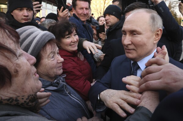 ARQUIVO - O presidente russo, Vladimir Putin, reúne-se com residentes após uma visita ao complexo de estufas Solnekhniy Dar, nos arredores de Stavropol, Rússia, em 5 de março de 2024.  Os eleitores vão às urnas na Rússia para uma eleição presidencial de três dias.  Estender o governo de Putin após suprimir a dissidência.  (AP, arquivo via Mikhail Metzel, Sputnik, Kremlin Pool Photo)