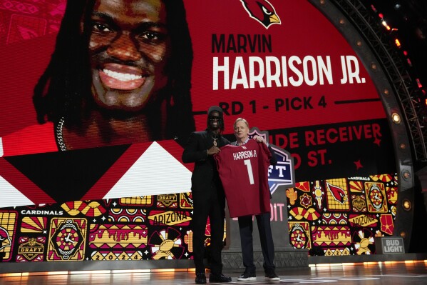 Ohio State wide receiver Marvin Harrison Jr. poses with NFL commissioner Roger Goodell after being chosen by the Arizona Cardinals with the fourth overall pick during the first round of the NFL football draft, Thursday, April 25, 2024, in Detroit. (AP Photo/Jeff Roberson)
