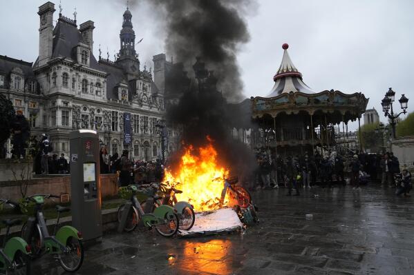 Bicycles burn during a protest outside the Paris City Hall, Friday, April 14, 2023 in Paris. France's Constitutional Council on Friday approved an unpopular plan to raise the retirement age from 62 to 64, in a victory for President Emmanuel Macron after three months of mass protests over the legislation that have damaged his leadership. The decision dismayed or enraged critics of the pension plan, including protesters gathered outside Paris City Hall as the decision came down. (AP Photo/Michel Euler)