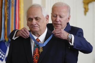 President Joe Biden awards the Medal of Honor to Spc. Dwight Birdwell for his actions on Jan. 31, 1968, during the Vietnam War, during a ceremony in the East Room of the White House, Tuesday, July 5, 2022, in Washington. On Thursday, July 7, 2022, The Associated Press reported on posts falsely claiming that Biden presented the award backward. (AP Photo/Evan Vucci)