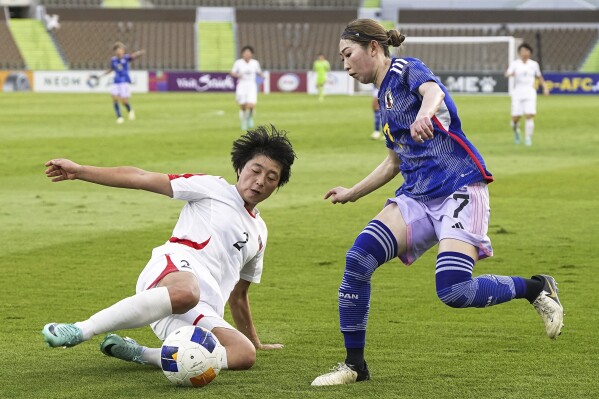 North Korea's Jon Hong Yon (2) tries to block Japan's Emi Nakajima (7) during their women's soccer match of the Olympic qualifier in Jeddah, Saudi Arabia, Saturday, Feb. 24, 2024. Japan and North Korea鈥檚 women played a scoreless draw on Saturday in their bid for a spot in this year's Paris Olympics. This means the place will be determined on Wednesday in the second-leg match at Tokyo's National Stadium where the winner will advance to the 12-team tournament in Paris. (Yuya Shino/Kyodo News via AP)