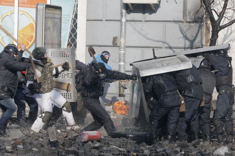 FILE - In this file photo taken on Feb. 18, 2014, anti-government protesters clash with riot police outside Ukraine's parliament in Kyiv, Ukraine. On Nov. 21, 2023, (AP Photo/Efrem Lukatsky, file)