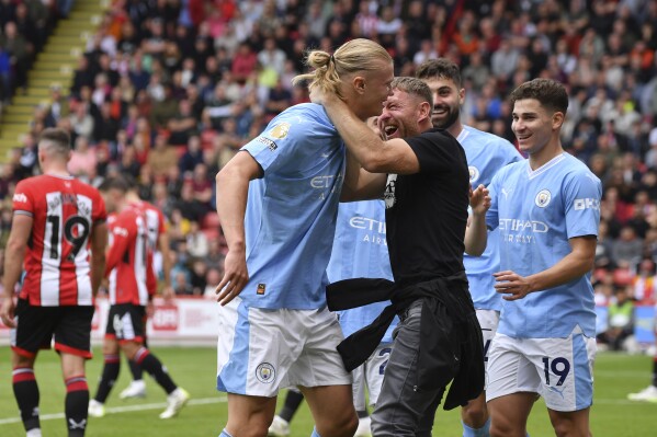 Manchester City's Erling Haaland, centre, celebrates after scoring his side's opening goal during the English Premier League soccer match between Sheffield United and Manchester City at Bramall Lane in Sheffield, England, Sunday, Aug. 27, 2023. (AP Photo/Rui Vieira)