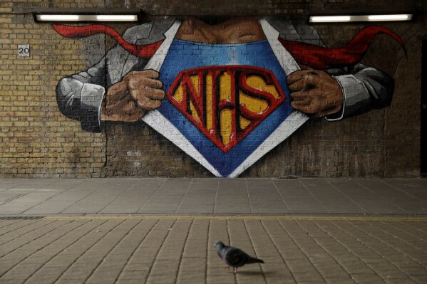A pigeon walks past a recently painted NHS (National Health Service) Superman design mural by street artist Lionel Stanhope during the coronavirus lockdown, in the Waterloo area of London, Sunday, May 3, 2020. The highly contagious COVID-19 coronavirus has impacted on nations around the globe, many imposing self isolation and exercising social distancing when people move from their homes. (AP Photo/Matt Dunham)