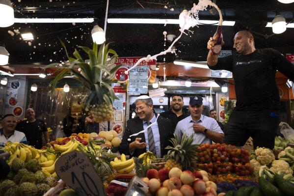 File - Israeli far-right lawmaker and the head of "Jewish Power" party, Itamar Ben-Gvir, center, and his supporters visit at Hatikva Market in Tel Aviv during his campaign ahead of the country's election, Friday, Oct. 21, 2022. (AP Photo/Oded Balilty, File)