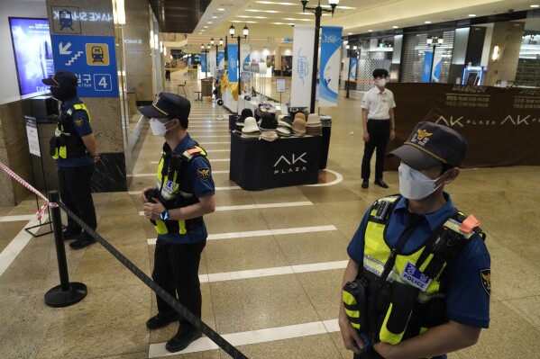 Police officers cordon off the scene near a subway station in Seongnam, South Korea, Thursday, Aug. 3, 2023. A dozen of people were injured in South Korea on Thursday when a man rammed a car onto a sidewalk and then stepped out of the vehicle and began stabbing people near a subway station in the city of Seongnam. (AP Photo/Ahn Young-joon)