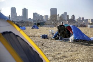 FILE-In this Tuesday, Jan. 27, 2015 file photo, Terry, cleans out his tent at a large homeless encampment, near downtown St. Louis. The gap between the haves and have-nots in the United States grew last year. Income inequality in the United States expanded from 2017 to 2018, with several heartland states among the leaders of the increase, even though several wealthy coastal states still had the most inequality overall, according to figures released Thursday, Sept. 26, 2019, by the U.S. Census Bureau. (AP Photo/Jeff Roberson)