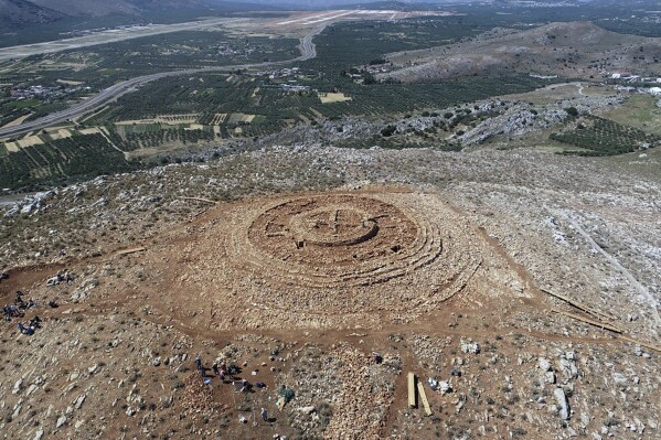 In this undated photo provided by the Greek Culture Ministry on Tuesday, June 11, 2024, the ruins of a 4,000-year-old hilltop building newly discovered on the island of Crete are seen from above. The wheel-shaped structure is puzzling archaeologists and threatening to disrupt a major airport project on the tourism-reliant island. Greece's Culture Ministry said Tuesday that it's a "unique and extremely interesting find" from Crete's Minoan civilisation, famous for its sumptuous palaces, flamboyant art and enigmatic writing system. (Greek Culture Ministry via AP)