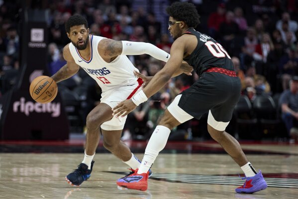 Los Angeles Clippers forward Paul George, left, dribbles the ball around Portland Trail Blazers guard Scoot Henderson during the second half of an NBA basketball game in Portland, Ore., Wednesday, March 20, 2024. (AP Photo/Craig Mitchelldyer)