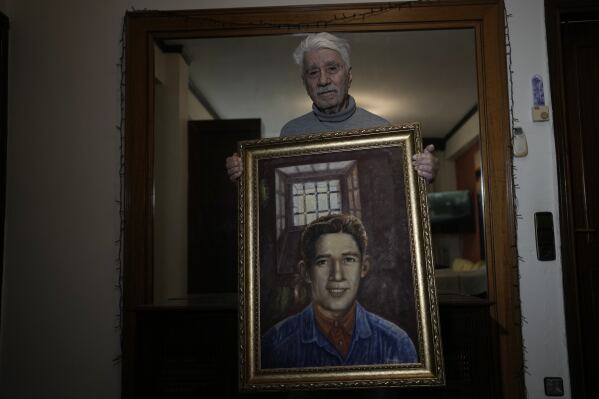 Agapios Sachinis holds a portrait of his uncle, a prisoner executed in the Greek Civil War, in Thessaloniki, Greece, on Saturday, April 12, 2025. (AP Photo/Thanassis Stavrakis)