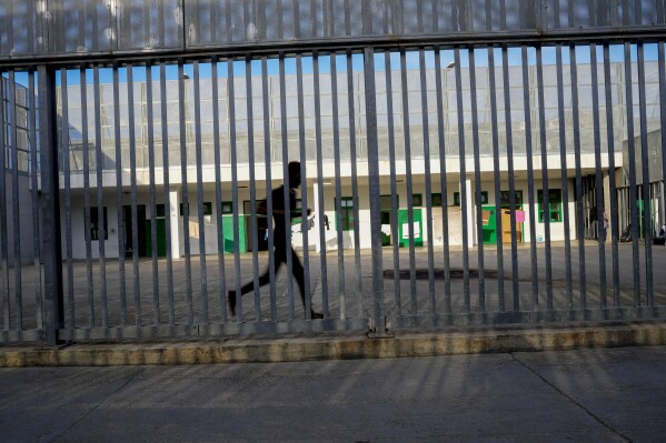 A detainee runs in an open area of the Ponte Galeria center, one of the facilities created in Italy to hold migrants ahead of their repatriation, as they are considered ineligible for refugee status or international protection, in Rome, Tuesday, March 19, 2024. (AP Photo/Andrew Medichini)