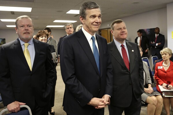 FILE - North Carolina Senate President Pro Tempore Phil Berger, left, North Carolina Gov. Roy Cooper, center, and House Speaker Tim Moore pause prior to a news conference, May 1, 2018, in Raleigh, N.C. A panel of North Carolina judges on Wednesday, Nov. 1, 2023, blocked for now changes the Republican-controlled legislature made to membership on three state boards that would end Cooper’s control of a majority of seats on each. (AP Photo/Gerry Broome, File)