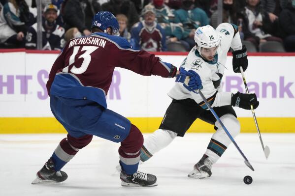 San Jose Sharks right wing Nick Merkley, right, picks up the puck as Colorado Avalanche right wing Valeri Nichushkin defends during the second period of an NHL hockey game Saturday, Nov. 13, 2021, in Denver. (AP Photo/David Zalubowski)