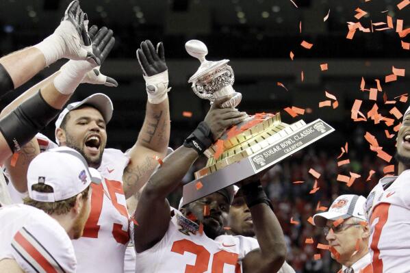 FILE - Ohio State linebacker Brian Rolle (36) holds up the Sugar Bowl trophy after they defeated Arkansas 31-26 during the Sugar Bowl NCAA college football game at the Louisiana Superdome in New Orleans, on Jan. 4, 2011. The 2010 season of the Ohio State University football team, vacated after a memorabilia-for-cash scandal, should be restored because of recent changes allowing college athletes to be compensated, under a symbolic resolution approved by Ohio lawmakers, Wednesday, May 18, 2022. (AP Photo/Patrick Semansky, File)