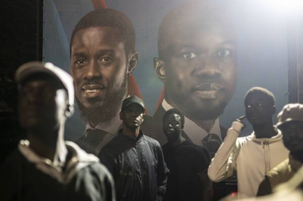 Supporters of presidential candidate Bassirou Diomaye Faye and Senegal's top opposition leader, Ousmane Sonko, gather outside their campaign headquarters as they await the results of the presidential election, in Dakar, Senegal, Sunday, March 24, 2024. (AP Photo/Mosa'ab Elshamy)