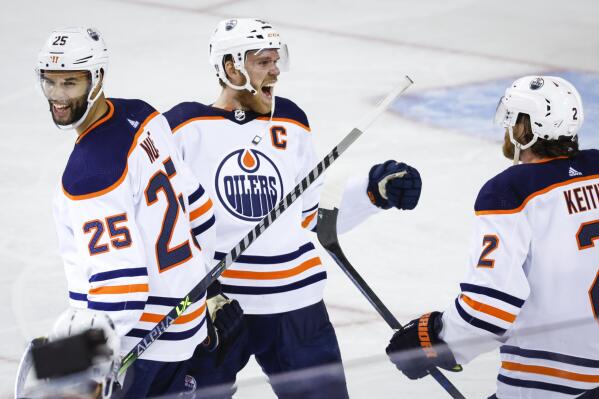 Edmonton Oilers center Connor McDavid, center, celebrates his goal against the Calgary Flames with defenseman Darnell Nurse, left, and defenseman Duncan Keith during overtime in Game 5 of an NHL hockey second-round playoff series Thursday, May 26, 2022, in Calgary, Alberta. (Jeff McIntosh/The Canadian Press via AP)